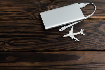 Plane and battery on dark wooden background. Electric plane or green plane concept.