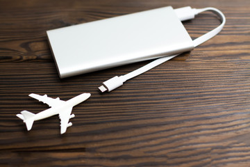 Plane and battery on dark wooden background. Electric plane or green plane concept. Copyspace. Charging modern plane which are the future of the Aircraft.