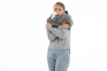 Young sick woman wrapped in a scarf on white background. Cold, flu, illness.