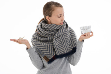 Young sick woman wrapped in a scarf on white background. Cold, flu, illness.