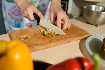 Girl cook cuts meat for a delicious tortilla