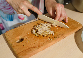Girl cook cuts meat for a delicious tortilla