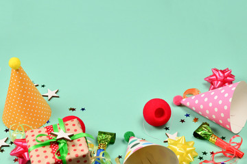 Birthday caps,  present, confetti, ribbons,  stars,  clown noses on a green background. Space for text or design.