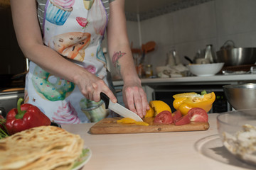 Girl cook makes cutting vegetables for tasty and juicy tortilla