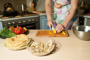 Girl cook makes cutting vegetables for tasty and juicy tortilla