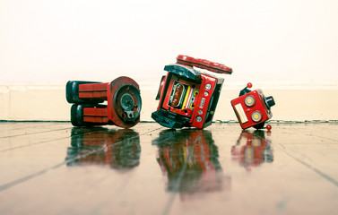 retro red robot sad and broken on old wooden floor