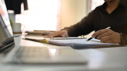 Businessman analysis on document paper with cropped shot.