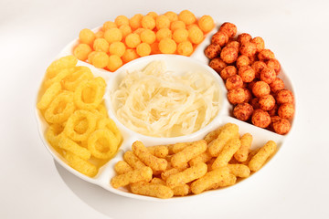 Mix of snacks on a white plate isolated on white.