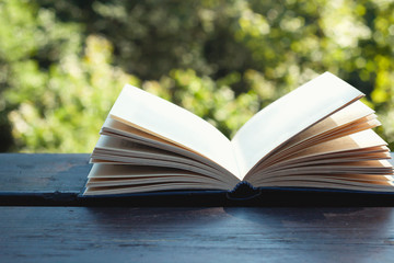 Old opwn book on garden wooden table