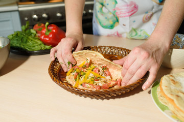 Girl cook cooks delicious tortilla pork and fresh vegetables