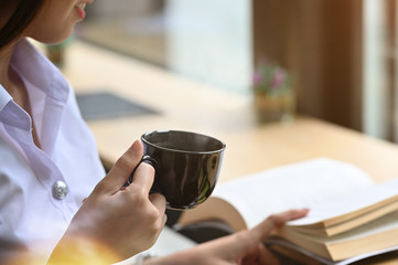 Fototapeta premium Cropped shot woman holding a coffee cup.