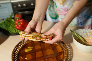 Girl cook cooks delicious tortilla pork and fresh vegetables