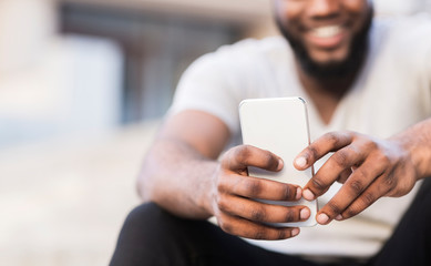 Unrecognizable african man making selfie and widely smiling
