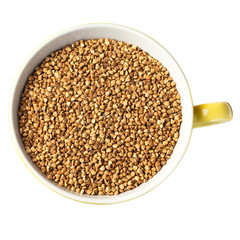 buckwheat kasha in a yellow mug, top view, isolated
