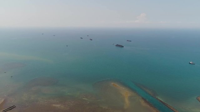 power station by sea with spillway into sea, barges full coal. paiton java, indonesia
