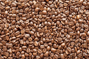 Texture of coffee beans scattered randomly. Brown texture.