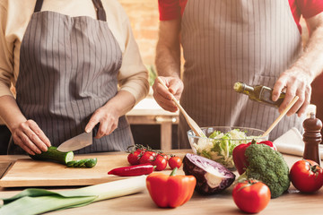 Mature couple preparing healthy vegetarian lunch at home kitchen