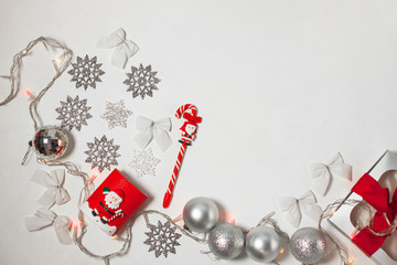 Christmas composition of red and silver decorations, gift box with ribbon bow, flatlay.