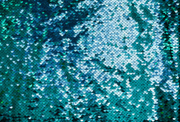 Shiny background made of turquoise sequins. Luxury scaly Background