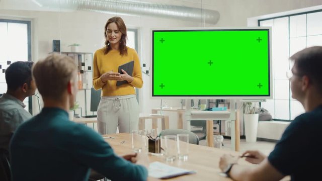 Female Project Manager Holds Meeting Presentation for a Team of Developers. She Shows Green Screen Interactive Whiteboard Device for Business Planning Concept. Young People Work in Creative Office