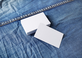 Photo of blank business cards on denim background. Template for ID.