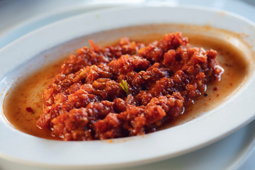 Italian tomato sauce with basil, onion and garlic on white wooden table.