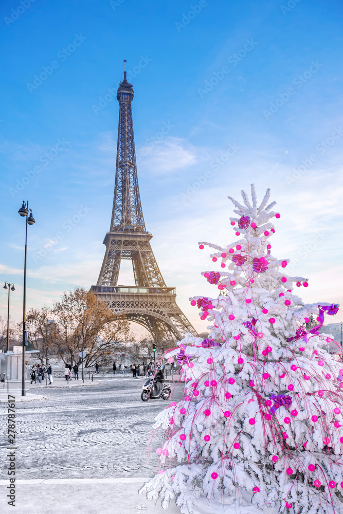 Wall mural eiffel tower is the main attraction of paris on the background of christmas trees covered by snow in