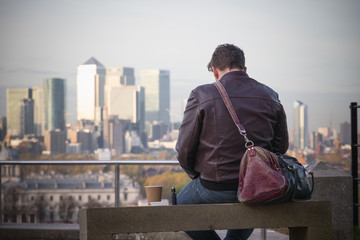 Back of a man enjoying the view of London cityscape from Greenwich hill 