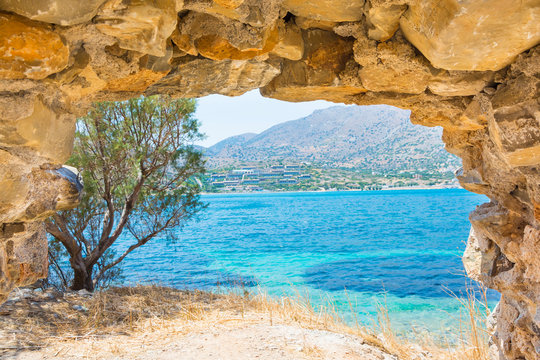 Beautiful view of the turquoise sea bay and mountain through ancient fortress of Spinalonga on island of Crete in Greece