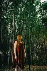 Redhead woman standing in a bamboo plantation