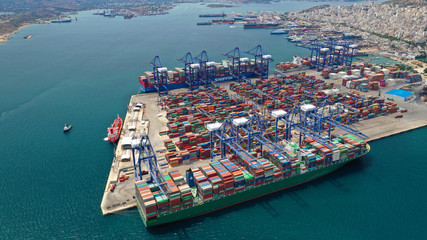 Aerial drone view of industrial cargo shipment and logistics port terminal with container trucks,...
