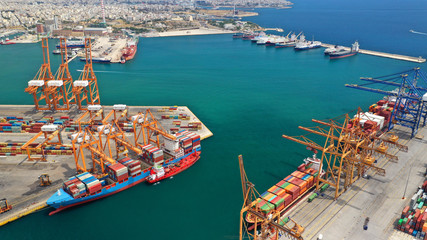 Aerial drone view of industrial cargo shipment and logistics port terminal with container trucks,...