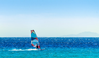 windsurfer on the background of high mountains rides on the waves of the Red Sea in Egypt Dahab South Sinai