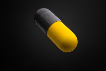 Floating or levitate black and yellow capsule pills in the thin air