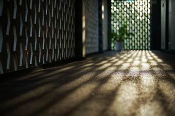 Selective focus on cement floor of corridor reflects the light of sunset with blurred bokeh lights...