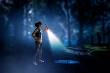 Young woman holding a flashlight