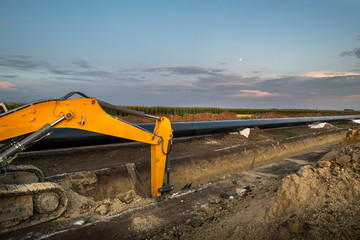 Crane digging a channel for gas pipeline