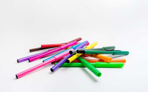 Multi-colored felt-tip pens randomly scattered on a white background. Back to school. Fine Arts Education.