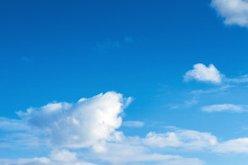Naklejka na ściany i meble fleecy clouds on an azure sky. beautiful nature background. dynamic side lit cloudscape