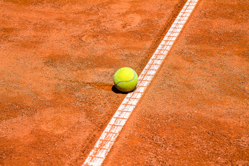 Tennis ball on a clay court close-up