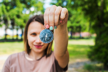 woman shows compass on nature background