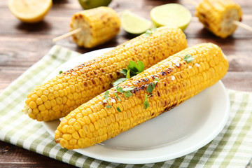 Grilled corn with green parsley leafs on brown wooden table