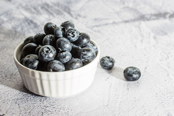 Blueberries with water drops on concrete background.