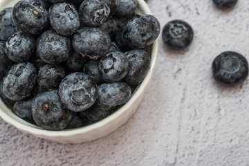 Blueberries with water drops on concrete background.