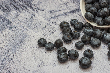 Blueberries with water drops on concrete background.