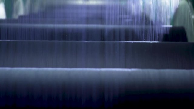 An industrial factory spins hundreds of miles of denim yarn through its rollers every day.