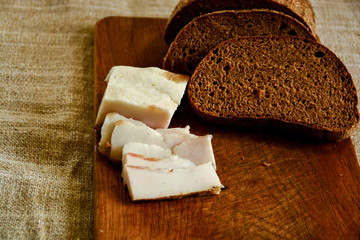 Freshly baked bread on a wooden cutting board with bacon