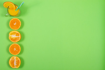 top view on glass of fresh orange juice on green background with place for text