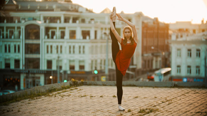 Young woman ballerina training on the roof - standing in the pose showing her stretching © KONSTANTIN SHISHKIN