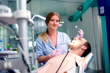 Young confident man at dentist's office for routine checkup.